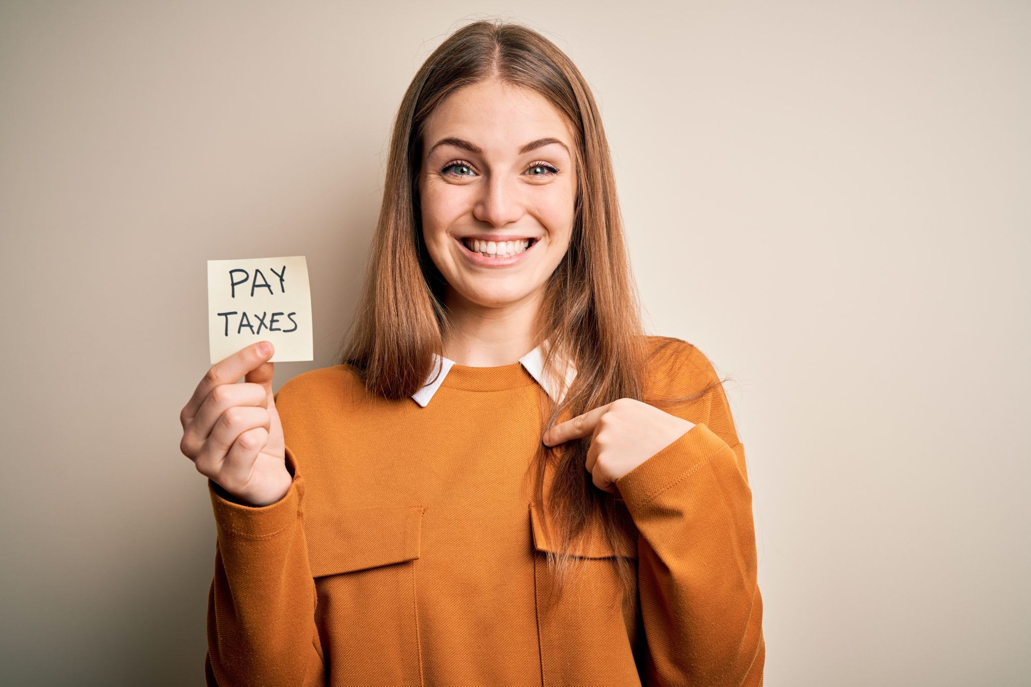 Young Beautiful Blonde Woman Holding Pay Taxes To Goverment Reminder Over Yellow Background With 2363